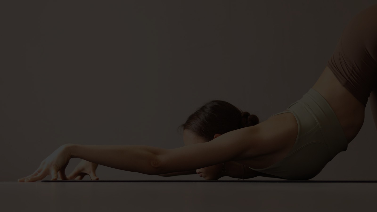 Жінка виконує асану йоги в світлій студії, поза воїна